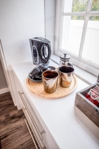 una mesa con dos tazas de café en una barra en Corner House Residence, en Franschhoek