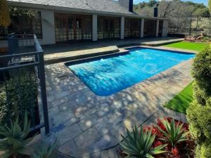 una piscina en el patio trasero de una casa en La Casa Guest House, en Bloemfontein