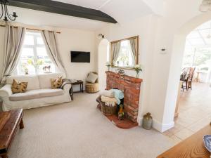 a living room with a couch and a fireplace at Far Coley Farm and Kilnhurst Log Cabin in Stafford