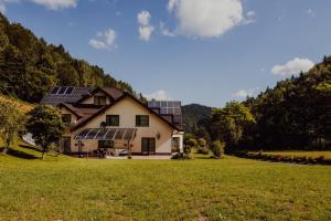 una casa con paneles solares al lado de un campo en Apartament pod Lubaniem en Ochotnica Dolna