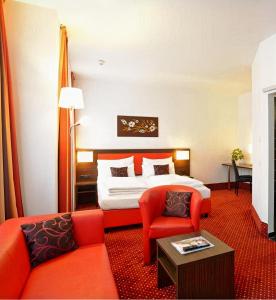 ウィーンにあるベスト ウエスタン プラス アメディア ウィーンのベッドとソファ付きのホテルルーム