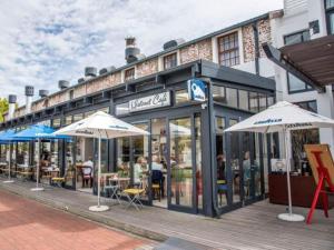 a restaurant with umbrellas in front of a building at Thesen View - exquisite views with bikes & canoe in Knysna
