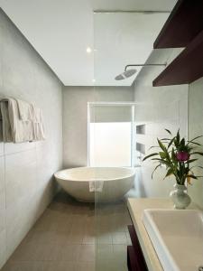 a white bathroom with a tub and a sink at Maison Leab in Siem Reap