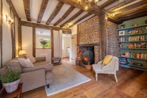 a living room with a couch and chairs and a fireplace at Angelic 16th Century cottage in key Constable village - Bear Cottage in Nayland