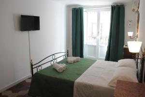 パレルモにあるLa Giaraのベッドルーム1室(緑のカーテンと窓付きのベッド1台付)
