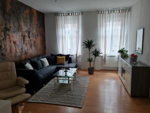 uma sala de estar com um sofá e uma mesa em Apartmenthaus Gratzer em Graz