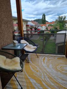 uma varanda com 2 cadeiras e uma mesa na varanda em Apartmenthaus Gratzer em Graz