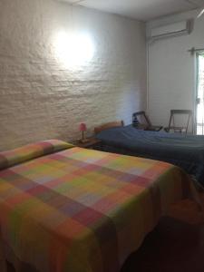 1 dormitorio con 2 camas y una manta colorida en Hospedaje Silvia, en Salto