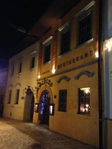 a building with a sign on the side of it at night at Pension - Restaurant Sabato in Poprad