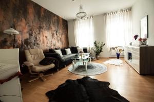 een woonkamer met een bank en een tafel bij Apartmenthaus Gratzer in Graz