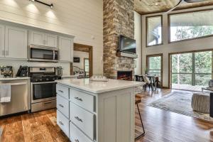 a large kitchen with white cabinets and a stove top oven at NEW Modern Cabin! 2 Large Decks, Hot Tub, Sleeps 8 in Ellijay