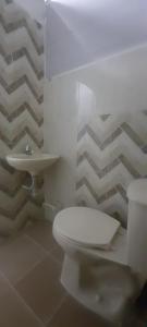 een badkamer met een wit toilet en een wastafel bij Apartamentos LUISA in Coveñas