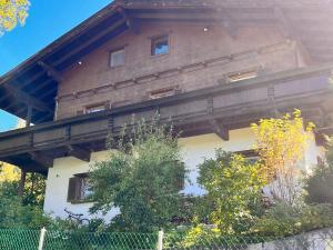 ein großes Holzhaus mit einem Zaun davor in der Unterkunft Haus Blang Einzelzimmer in Innsbruck