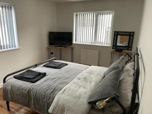 a bedroom with a bed with two towels on it at The New 2 Plas Morolwg in Aberystwyth