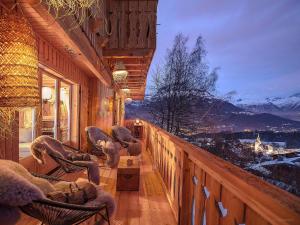 a balcony with chairs and a view of a mountain at CHALET LES CERISES Jacuzzi, Sauna, Hammam, Cinéma in Cordon