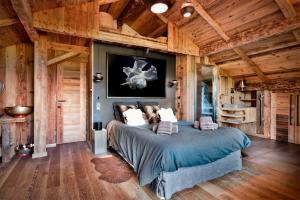 a bedroom with a bed in a room with wooden walls at CHALET LES CERISES Jacuzzi, Sauna, Hammam, Cinéma in Cordon