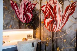 La salle de bains est pourvue d'un lavabo et d'un rideau de douche avec des fleurs. dans l'établissement Golden Tulip Hotel Central, à Bois-le-Duc