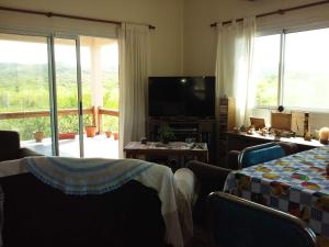 un soggiorno con 2 tavoli e una TV di Casa en Villa Los Aromos a La Bolsa