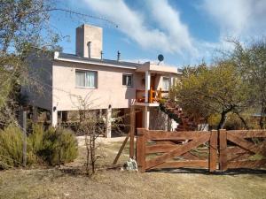ein Haus mit einem Zaun davor in der Unterkunft Casa en Villa Los Aromos in La Bolsa