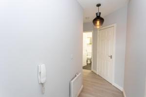 un corridoio con una porta e un telefono appeso a un muro di Pillo Rooms Serviced Apartments - Trafford a Manchester