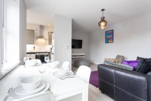 un soggiorno con tavolo bianco e divano di Pillo Rooms Serviced Apartments - Trafford a Manchester