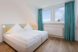 a bedroom with a white bed and a window at Lieblingshome in Tinnum