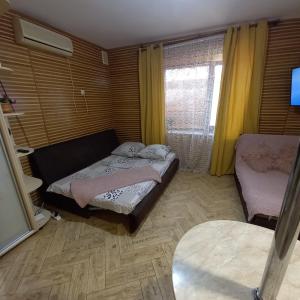1 dormitorio con cama, sofá y ventana en Апартаменты-студио, en Izmaíl