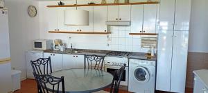 a kitchen with a table and chairs in a kitchen at CASA EN PLAYA DE RAZO CON JARDIN Y VISTAS AL MAR in Razo