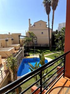 a balcony with a swimming pool and a house at Studio Beach & Golf in Torre de Benagalbón