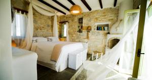 a bedroom with two beds and a stone wall at Dream Villa Santa Maria in Santa Maria