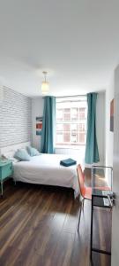 een slaapkamer met een groot bed en een raam bij Location Location Location, Whole apartment for you! in Londen
