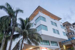 een wit gebouw met palmbomen ervoor bij PlazaMar Pacifico Hotel in Buenaventura