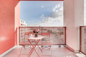 einen Balkon mit einem Tisch und Stühlen sowie einem Fenster in der Unterkunft ARI Brownie Apartment near AFI Mall in Arad