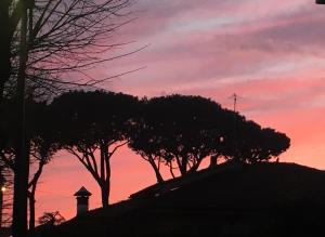 a sunset with trees and a cross on a hill at Superbe Villa toscane entre plage et verdure in Camaiore