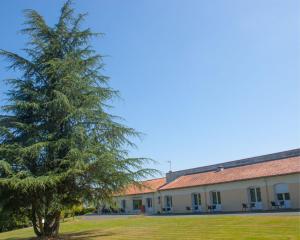 een dennenboom voor een gebouw bij Domaine du Bocage in Chavagnes-en-Paillers