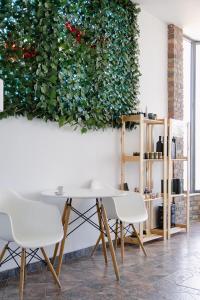 a table and chairs in a room with a green wall at Calma Beach Hotel in Stavros