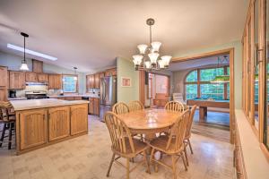 una cucina e una sala da pranzo con tavolo e sedie in legno di Tranquil Cabin Getaway Near Red Cedar Lake! a Birchwood