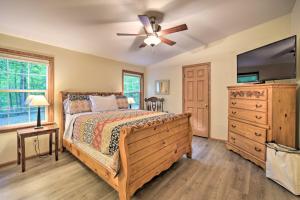 una camera con letto e ventilatore a soffitto di Tranquil Cabin Getaway Near Red Cedar Lake! a Birchwood