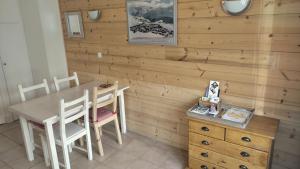 a dining room with a table and chairs and a wooden wall at Studio des Jeux - Alpe d'Huez Hyper Centre - 4-5 personnes - Wifi in LʼHuez