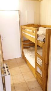 a room with two bunk beds and a refrigerator at Studio des Jeux - Alpe d'Huez Hyper Centre - 4-5 personnes - Wifi in LʼHuez