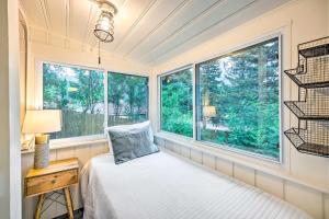 a bedroom with a bed and two windows at Charming Cascade Cabin about 1 Mi To Pikes Peak! in Cascade-Chipita Park