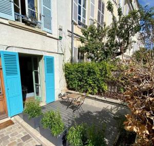 a bench sitting in front of a building with blue doors at STUDIO HYPER CENTRE SAINT GERMAIN EN LAYE in Saint-Germain-en-Laye