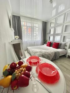 Zimmer mit einem Tisch mit Obst und Weingläsern in der Unterkunft Apartment Studio PARIS 92 in Irpin