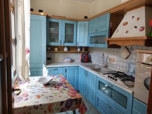 a kitchen with blue cabinets and a table with a tablecloth at Dimora La Genuina in Guspini