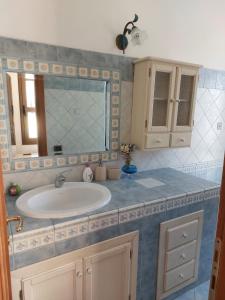 a bathroom with a sink and a mirror at Bilocale La Genuina in Guspini