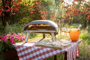 a grill on a table with pizzas and glasses of wine at 8-Bed Lotus Belle Mahal Tent in The Wye Valley in Ross on Wye