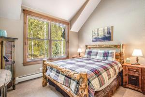 a bedroom with a wooden bed and a window at Alpine Holidays Ski Tip in Keystone