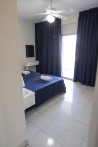 a bedroom with a blue bed and a blue curtain at Larnaca Center Apartments in Larnaka