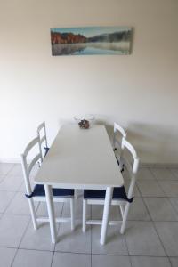 a white table and chairs with a painting on the wall at Larnaca Center Apartments in Larnaka