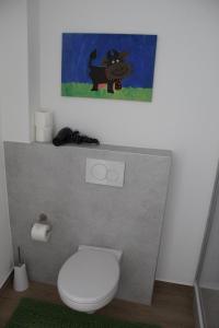 a bathroom with a toilet with a painting on the wall at Auszeit im Rheingau in Eltville